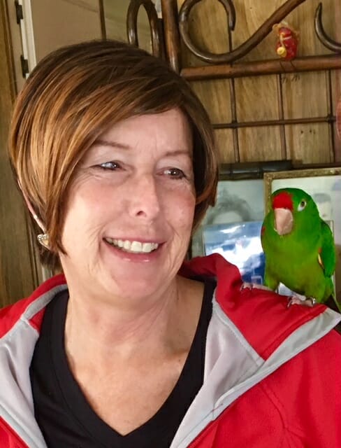 Shoo with a green parrot on her shoulder.